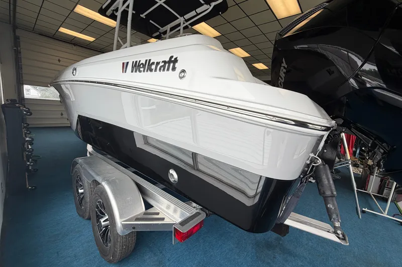 Slide: The Image of 2027 Wellcraft 202 Fisherman boat on trailer in showroom, featuring sleek design and modern features. - 5