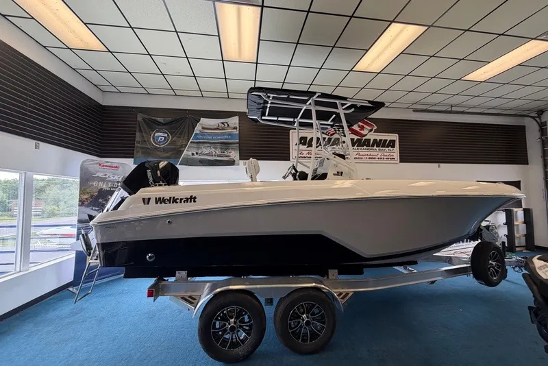 Slide: The Image of 2027 Wellcraft 202 Fisherman boat displayed indoors on a trailer. - 3