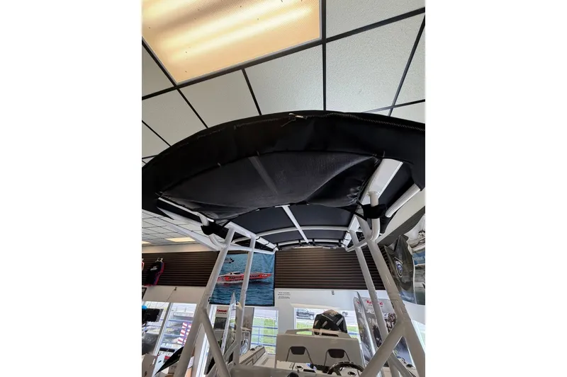 Slide: The Image of 2027 Wellcraft 202 Fisherman boat interior with T-top canopy in showroom. - 26