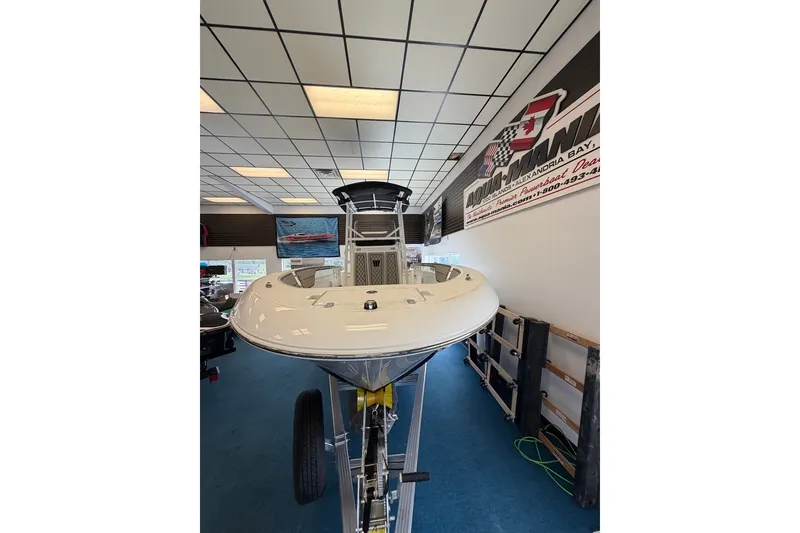 Slide: The Image of 2027 Wellcraft 202 Fisherman boat displayed indoors on a trailer. - 16