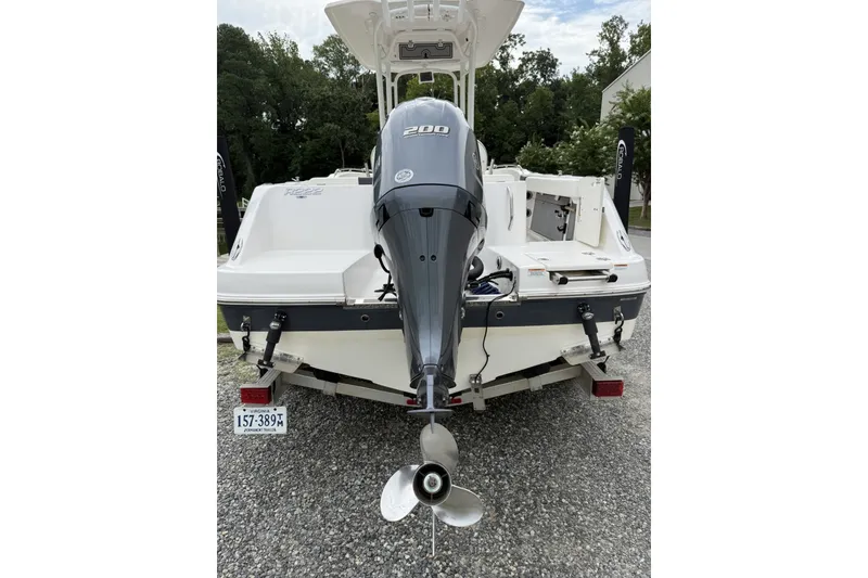 Slide: The Image of 2022 Robalo R222 Center Console boat with powerful outboard motor, parked on gravel. - 8