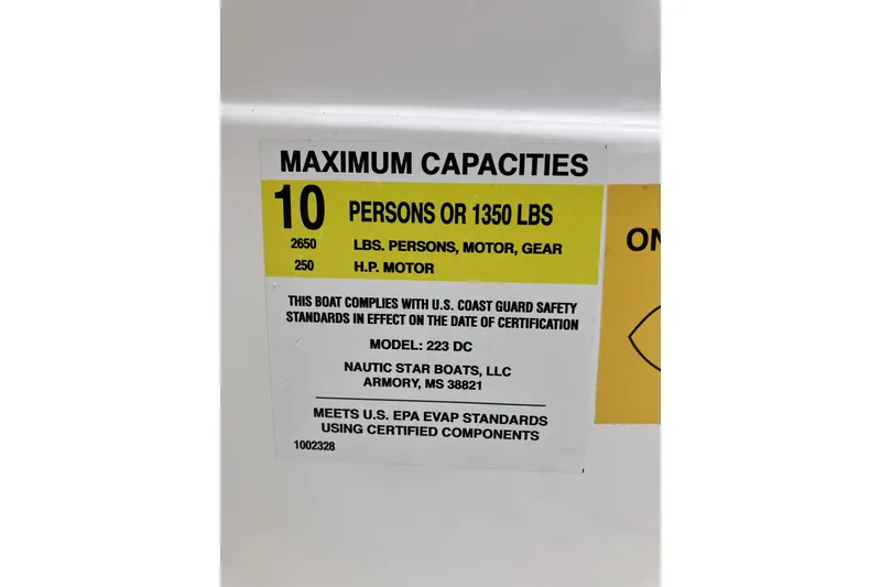 Slide: The Image of 2025 NauticStar 223 DC Deck boat capacity label, 10 persons or 1350 lbs, safety standards compliant. - 8
