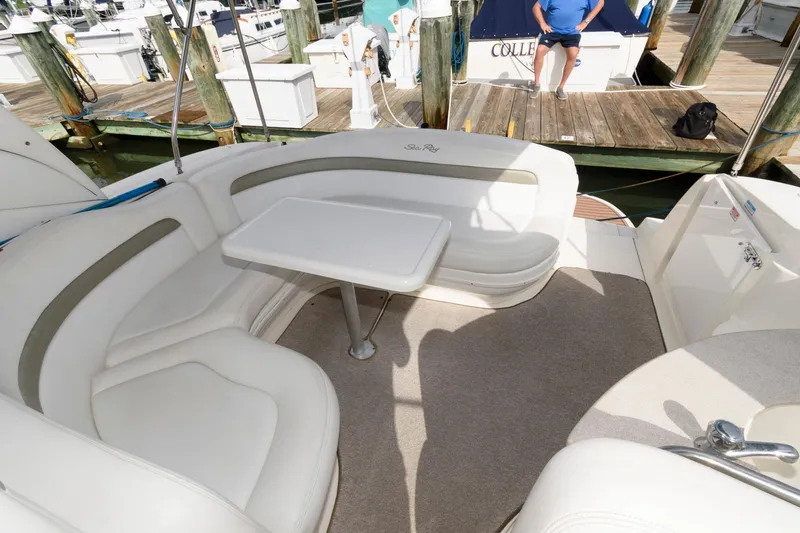 Slide: The Image of The image shows the seating area of a 2006 Sea Ray Sundancer 320 with a table. - 9
