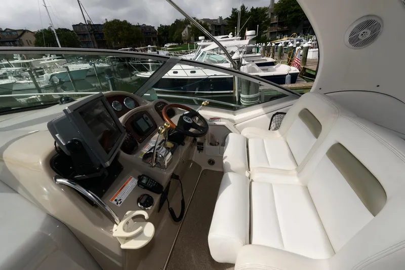Slide: The Image of The image shows the cockpit of a 2006 Sea Ray Sundancer 320 with white seats and a helm console. - 5