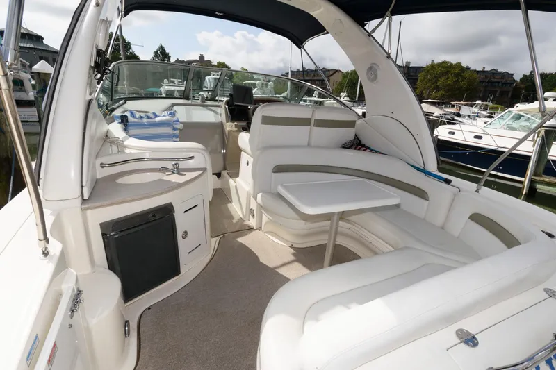 Slide: The Image of The image shows the cockpit of a 2006 Sea Ray Sundancer 320 with comfortable seating and a table. - 2
