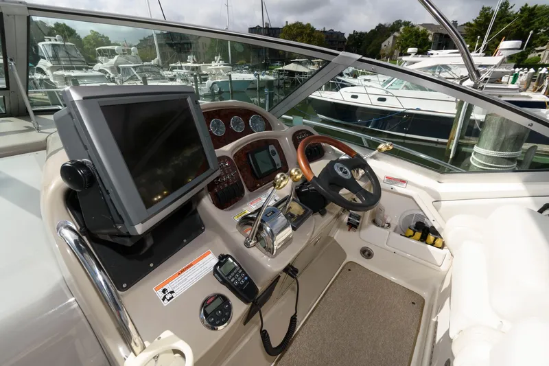 Slide: The Image of The cockpit of a 2006 Sea Ray Sundancer 320 with steering wheel, instruments, and a large screen. - 6