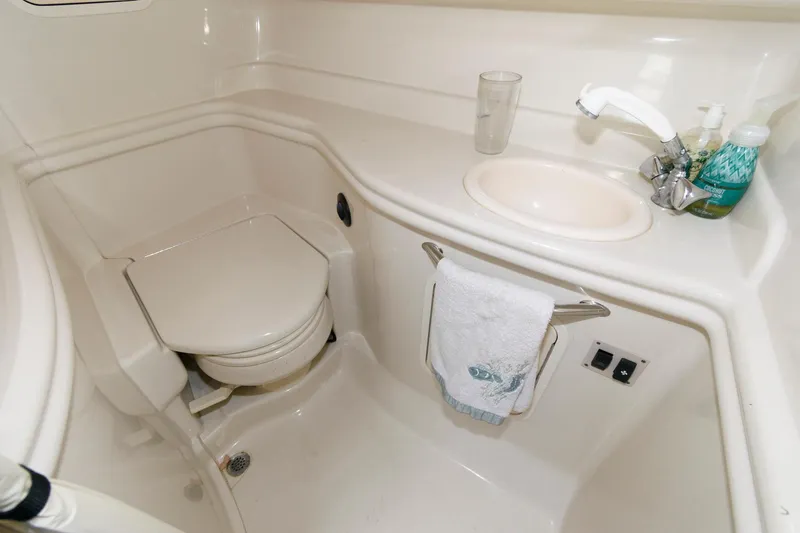 Slide: The Image of The image shows a clean boat bathroom with a toilet, sink, and towel holder. - 21
