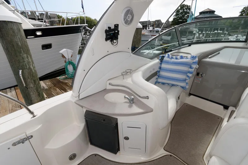 Slide: The Image of The image shows the cockpit of a 2006 Sea Ray Sundancer 320 with a small sink and seating area. - 10