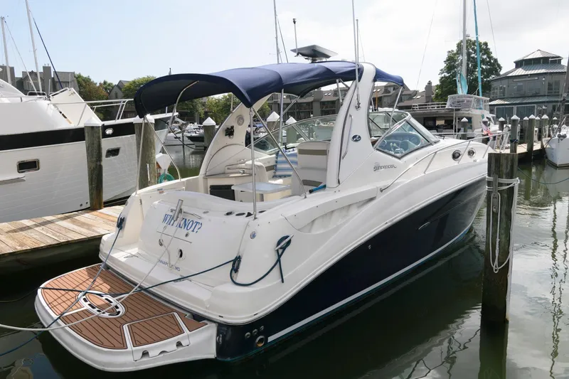 Slide: The Image of A 2006 Sea Ray Sundancer 320 docked. It features a blue canopy and a spacious swim platform. - 13