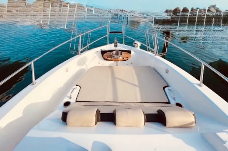Slide: The Image of Luxury Granfort 370 GTX yacht deck, 2026 model, with sunbathing area and scenic water view. - 2