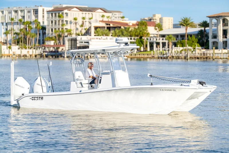 The Image of 2020 Costa Custom Boats 264HC cruising on a sunny waterfront with modern buildings in the background. - 0