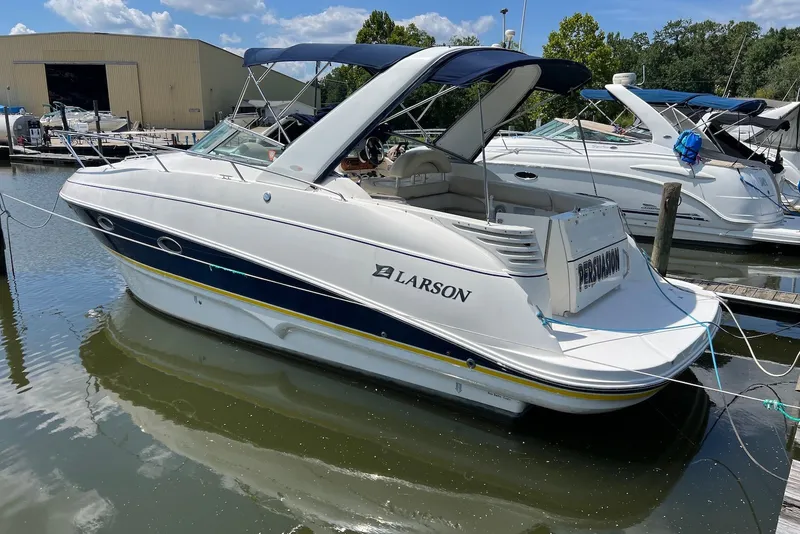 The Image of 2006 Larson Cabrio 310 boat docked at marina under clear sky. - 0