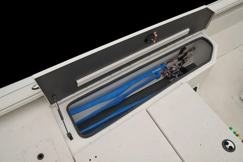Slide: The Image of The image shows the storage compartment of a 2024 Ranger RB210 boat with fishing rods. - 35