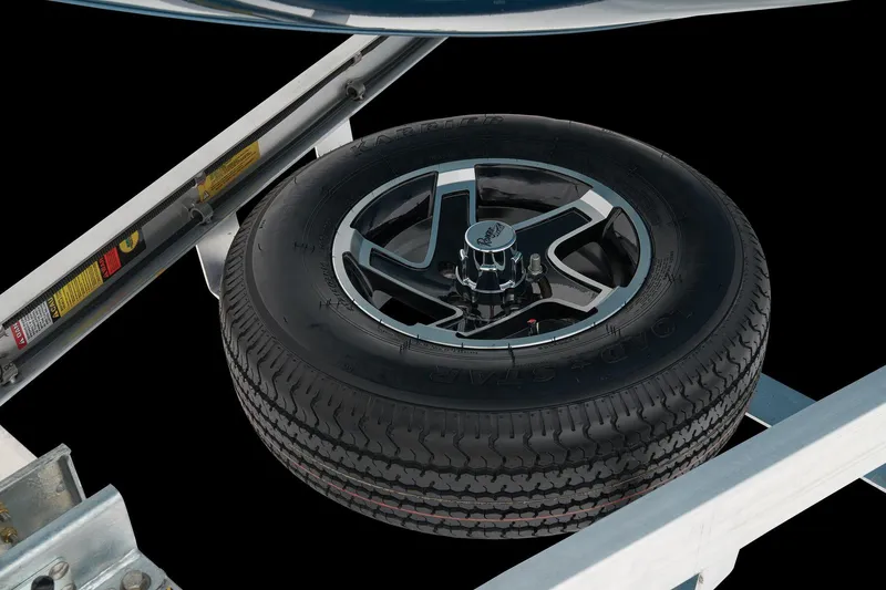 Slide: The Image of A spare tire with a shiny rim is mounted on a boat trailer. - 23