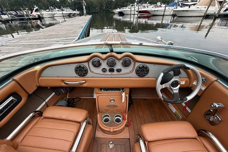 Slide: The Image of 2011 Chris-Craft Silver Bullet 20 boat interior with tan leather seats and classic dashboard. - 15