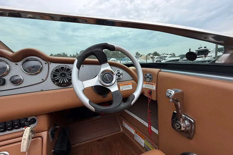 Slide: The Image of 2011 Chris-Craft Silver Bullet 20 boat interior with steering wheel and dashboard controls. - 16