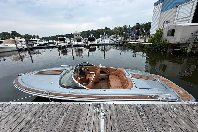 Slide: The Image of 2011 Chris-Craft Silver Bullet 20 boat docked at a marina, showcasing sleek design and luxury. - 5