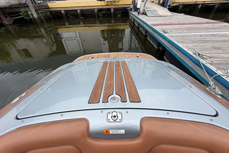 Slide: The Image of 2011 Chris-Craft Silver Bullet 20 boat docked, featuring sleek design and wooden accents. - 21