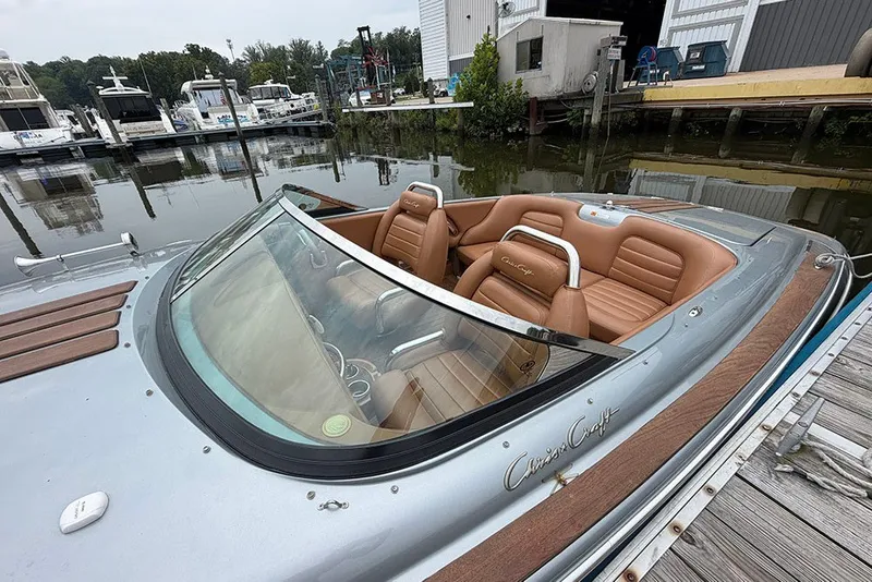 Slide: The Image of 2011 Chris-Craft Silver Bullet 20 boat with tan leather seats docked at marina. - 8