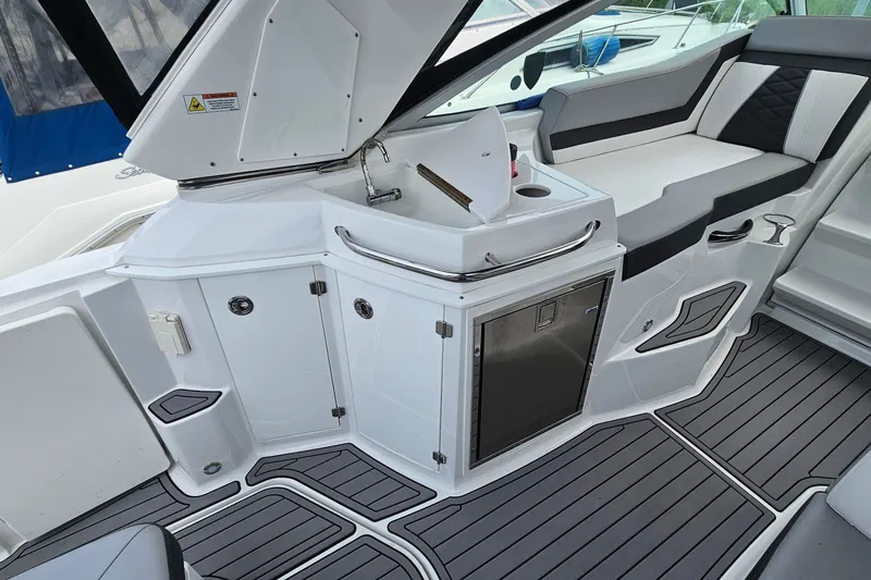 Slide: The Image of Interior of 2021 Monterey 295 Sport Yacht featuring sleek seating and compact kitchenette. - 8