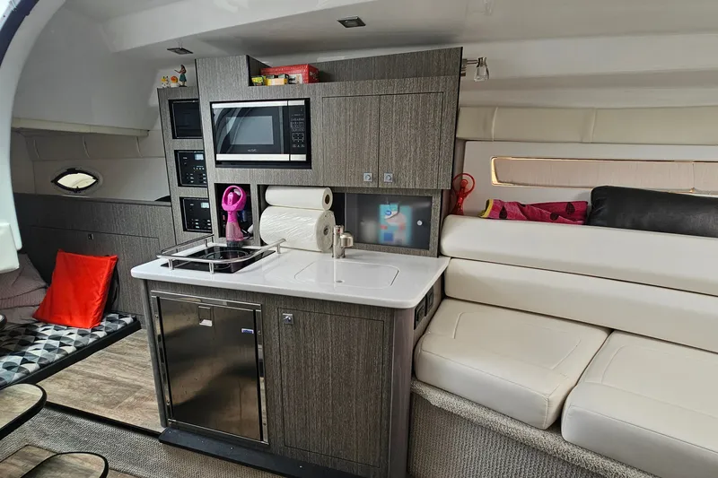 Slide: The Image of Interior of 2021 Monterey 295 Sport Yacht with modern kitchen and seating area. - 15