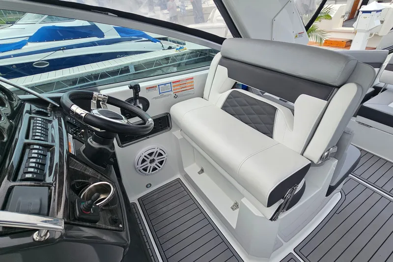 Slide: The Image of 2021 Monterey 295 Sport Yacht helm with modern steering and seating. - 10