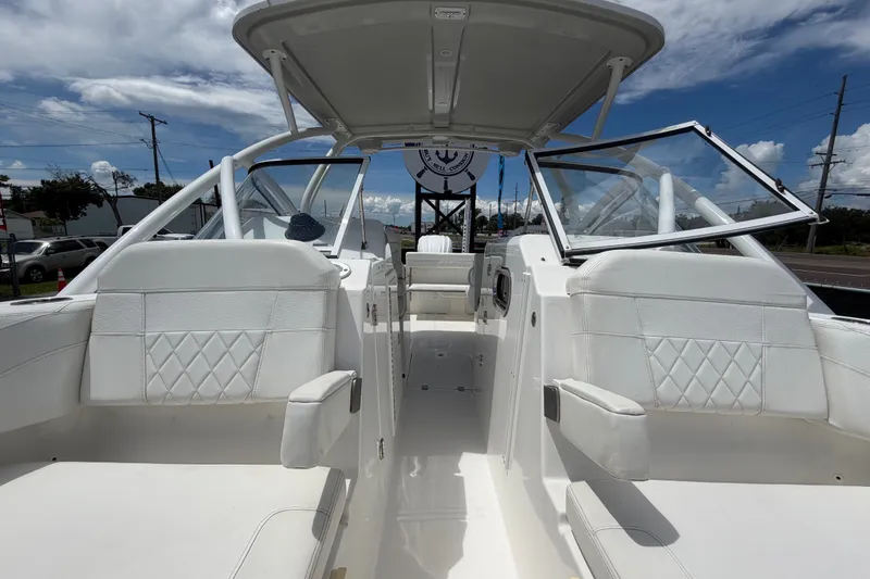 Slide: The Image of 2023 Edgewater 248CX Crossover boat interior with white seating and open windshield. - 73