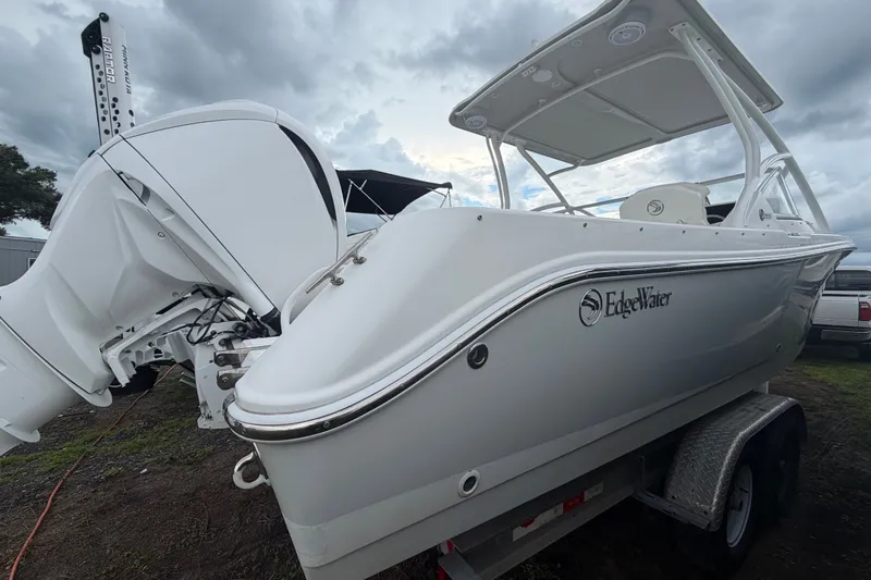 Slide: The Image of 2023 Edgewater 248CX Crossover boat on trailer, featuring sleek design and powerful engine. - 2