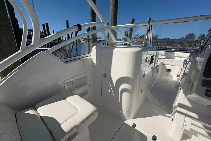 Slide: The Image of 2023 Edgewater 248CX Crossover boat interior with white seating and sleek design. - 25