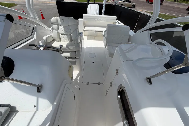 Slide: The Image of 2023 Edgewater 248CX Crossover boat interior with white seating and steering wheel. - 75