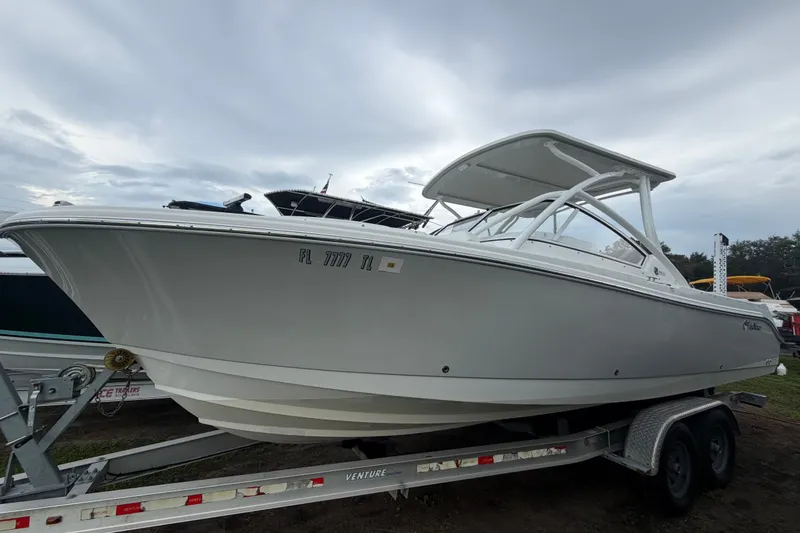 Slide: The Image of 2023 Edgewater 248CX Crossover boat on trailer under cloudy sky. - 0