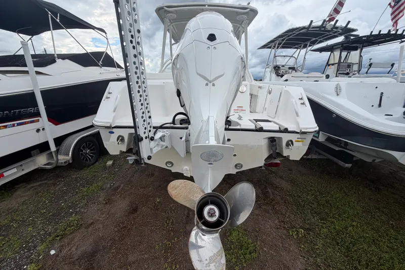 Slide: The Image of 2023 Edgewater 248CX Crossover boat rear view with outboard motor and propeller. - 1