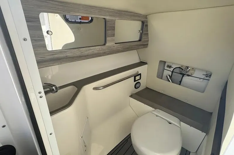 Slide: The Image of 2023 Edgewater 248CX Crossover boat interior with compact bathroom and modern fixtures. - 35