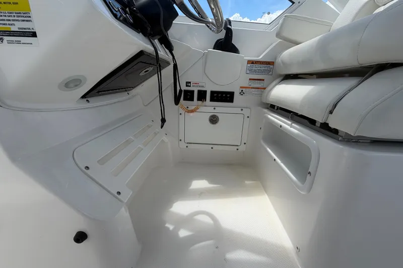 Slide: The Image of Interior view of 2023 Edgewater 248CX Crossover boat cockpit with white seating and controls. - 47