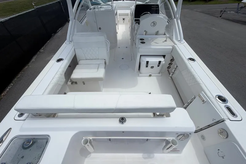 Slide: The Image of 2023 Edgewater 248CX Crossover boat interior with white seating and modern amenities. - 14