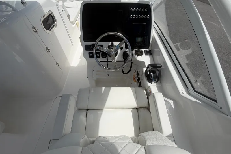 Slide: The Image of 2023 Edgewater 248CX Crossover boat cockpit with steering wheel and control panel. - 37