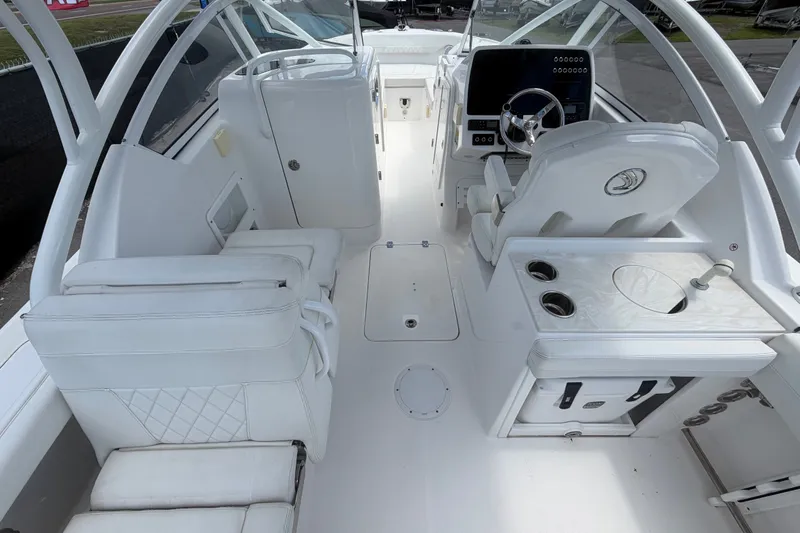 Slide: The Image of 2023 Edgewater 248CX Crossover boat interior with white seating and modern dashboard. - 21