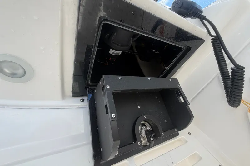 Slide: The Image of 2023 Edgewater 248CX Crossover boat compartment with open hatch and visible wiring. - 53