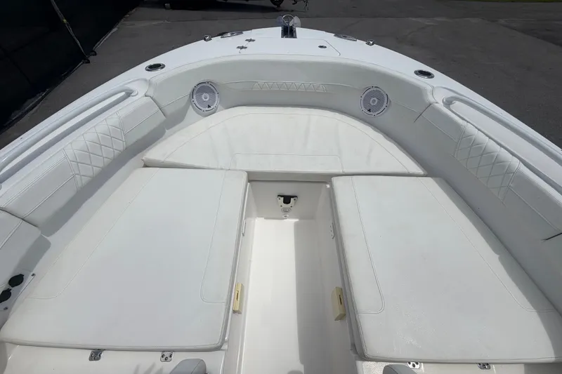Slide: The Image of 2023 Edgewater 248CX Crossover boat interior with white cushioned seating and speakers. - 61