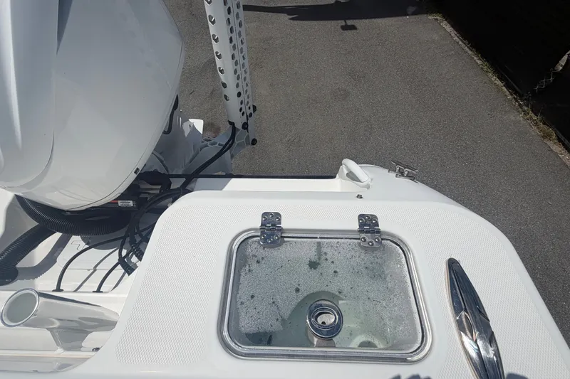 Slide: The Image of 2023 Edgewater 248CX Crossover boat with livewell and motor detail. - 84
