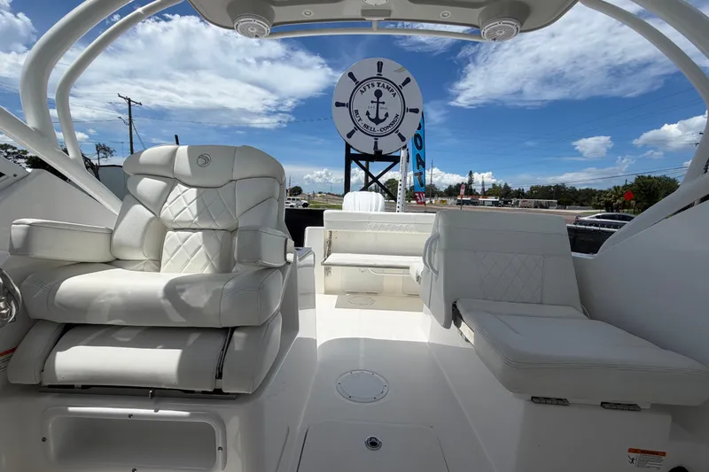 Slide: The Image of 2023 Edgewater 248CX Crossover boat interior with luxurious white seating under a clear blue sky. - 76
