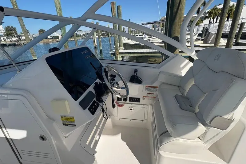 Slide: The Image of 2023 Edgewater 248CX Crossover boat cockpit with steering wheel and comfortable seating. - 36
