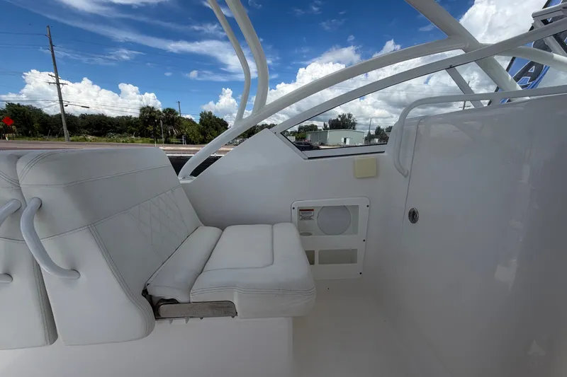 Slide: The Image of Interior of 2023 Edgewater 248CX Crossover boat with white seating and clear skies. - 28