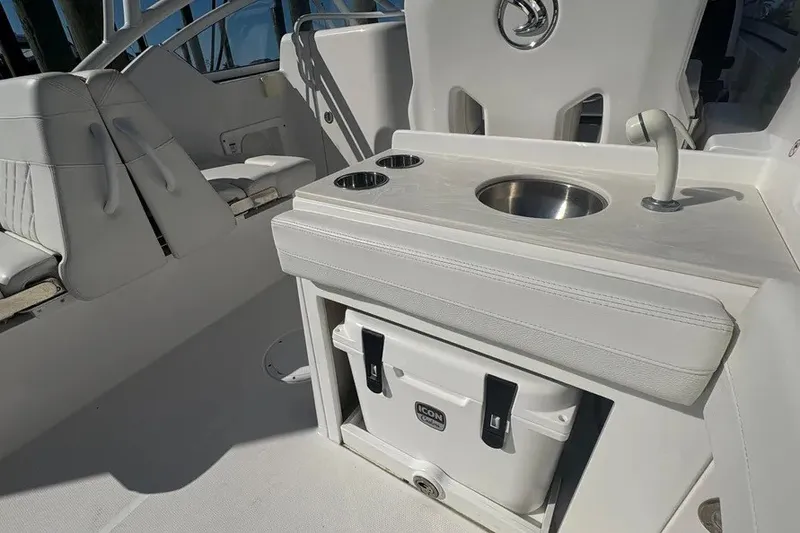 Slide: The Image of 2023 Edgewater 248CX Crossover boat interior with sink, cooler, and seating. - 27