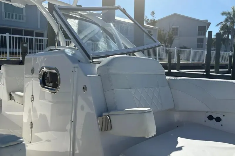 Slide: The Image of 2023 Edgewater 248CX Crossover boat interior with white seating and windshield. - 24