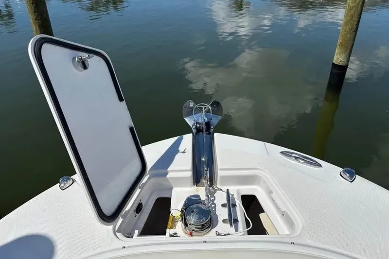 Slide: The Image of Open anchor compartment on 2023 Edgewater 248CX Crossover boat, docked on calm water. - 21