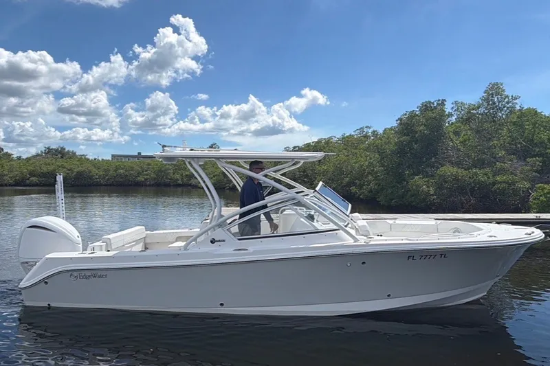 Slide: The Image of 2023 Edgewater 248CX Crossover boat on calm water, under a partly cloudy sky. - 87