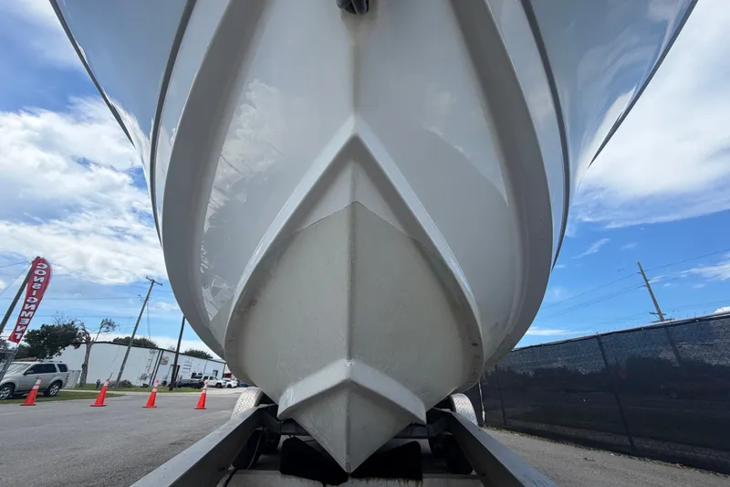 Slide: The Image of 2023 Edgewater 248CX Crossover boat on trailer, viewed from below, against a clear sky. - 11