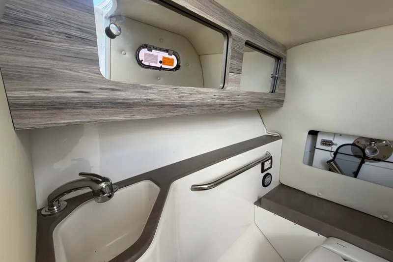 Slide: The Image of 2023 Edgewater 248CX Crossover boat interior with sink and storage cabinets. - 32