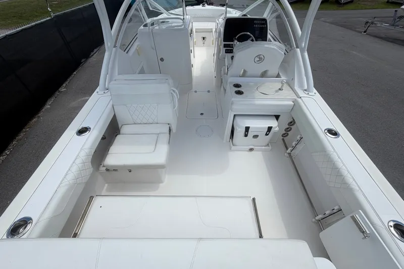 Slide: The Image of 2023 Edgewater 248CX Crossover boat interior with white seating and modern dashboard. - 15